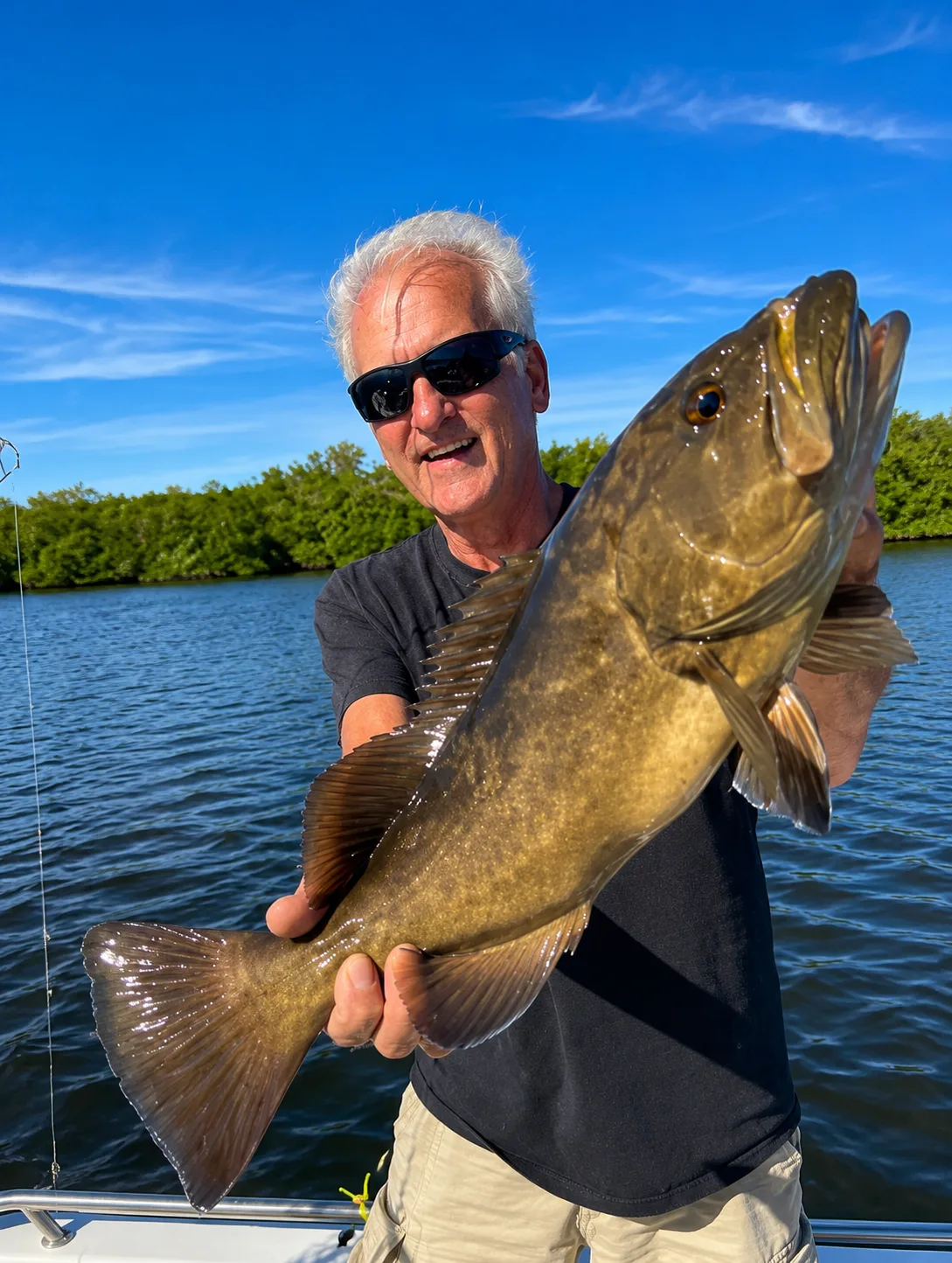 A gag grouper held up on the boat
